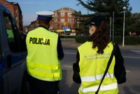 policjant i młodzieżowa służba ruchu drogowego podczas zabezpieczenia biegu