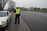 policjant z drogówki kontrolujący pojazd