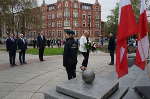 na zdjęciu delegacja władz miasta stoi przed pomnikiem