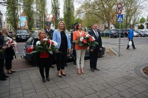 na zdjęciu delegacja władz miasta z wiązankami kwiatów