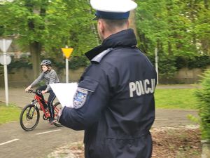na zdjęciu policjant z drogówki i dziecko na rowerze na miasteczku ze znakami
