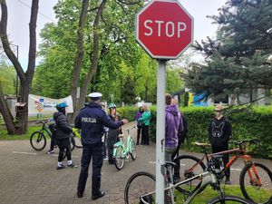 na zdjęciu policjant z drogówki i dzieci na rowerach